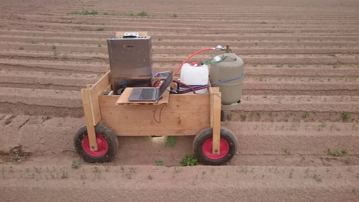 Früher Prototyp: Holzwagen mit Wassererhitzer, Kanister, Gasflasche und Laptop zwischen den Reihen