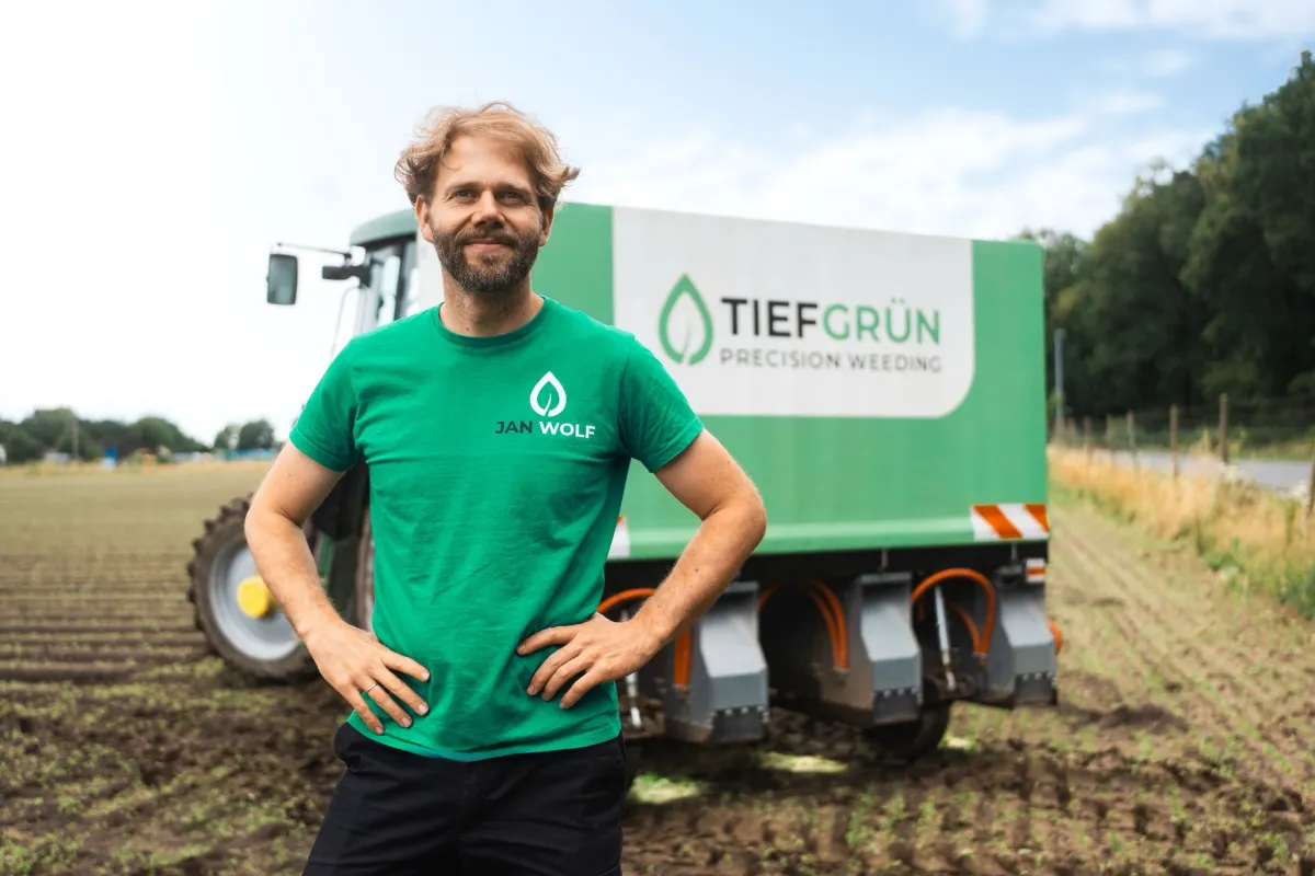 Jan Wolf steht vor dem Kelvin R370 auf dem Feld